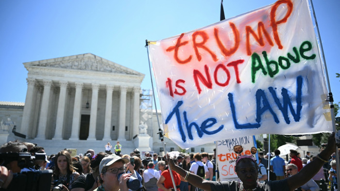 People hold anti Trump signs in front of the US Supreme Court
