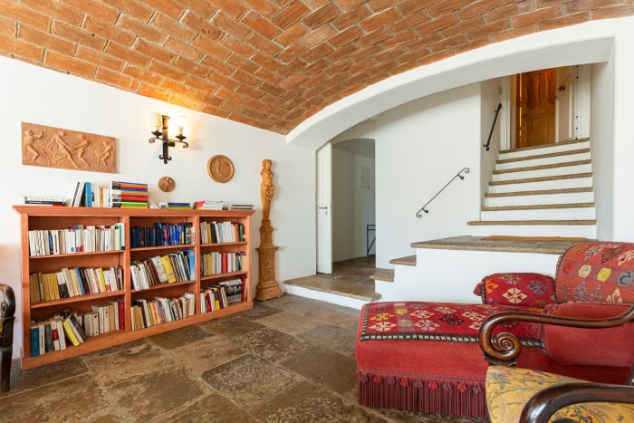 A cosy room with whitewashed walls, brick arched ceiling and flagstone floors 