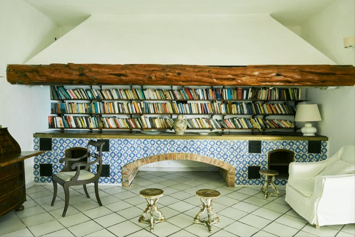 The reading room’s blue-tiled low former fireplace, with shelves of books between it and the chimney