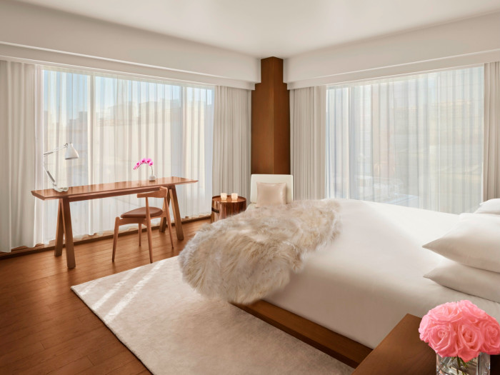 One of the hotel’s rooms, with a white faux-fur thrown over the bed, which looks onto floor-to-ceiling windows covered with a gauzy curtain