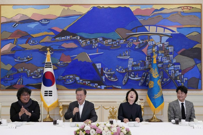 South Korean President Moon Jae-in speaks as Bong Joon-ho, director of the four-Oscar award-winning film ‘Parasite’, reacts during a luncheon at the Presidential Blue House in Seoul, South Korea, in 2020