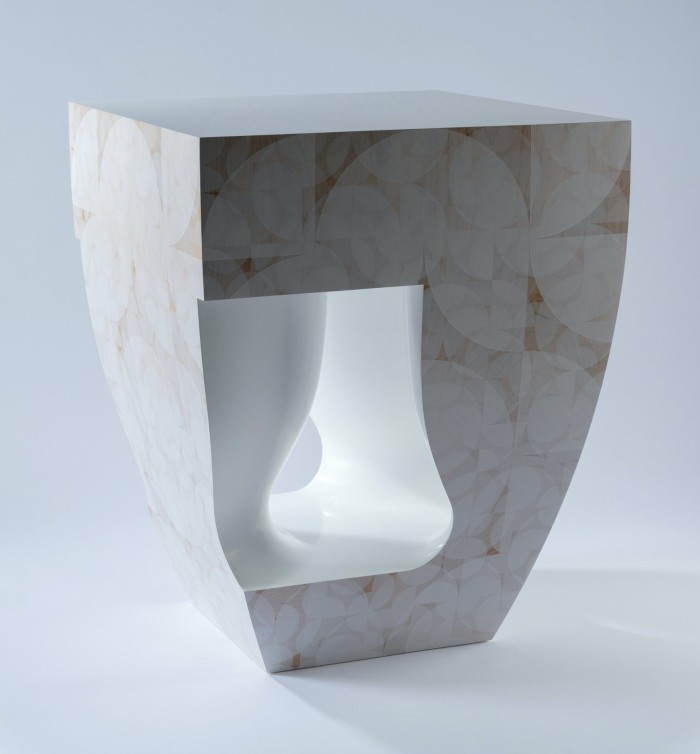 A white marble-effect table that looks carved from an angular block of material