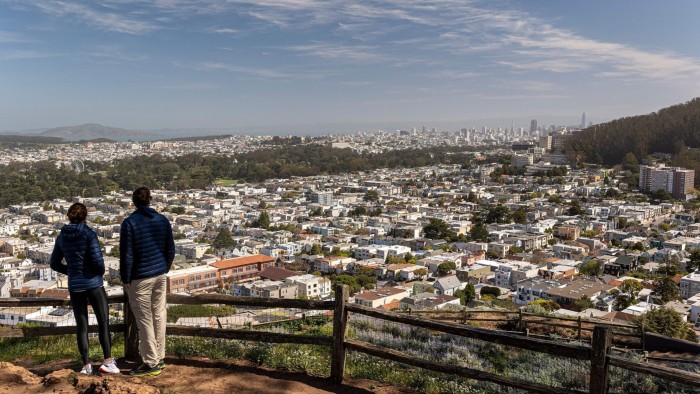Two people looking out over a residential area in San Francisco, their backs to the camera 