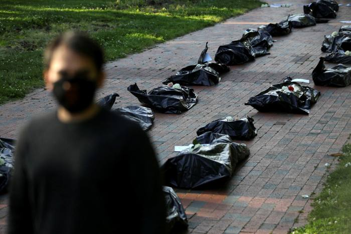 A protester walks past simulated body bags at a funeral procession demonstration for Covid-19 victims outside the White House in Washington last week
