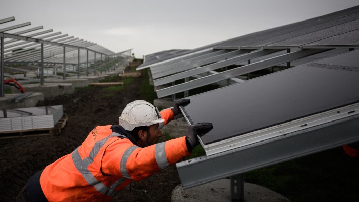 An employee installs solar panels in Pessac on the outskirts of Bordeaux, France