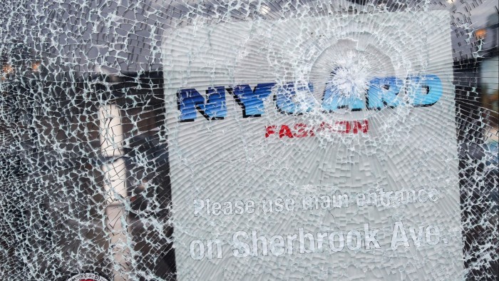Shattered glass obscures a sign bearing the name of fashion executive and designer Peter Nygard 
