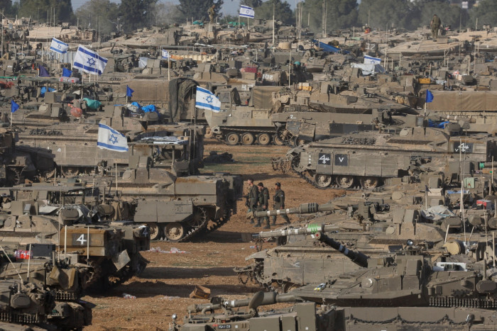 IDF soldiers walk amid a sea of armoured vehicles
