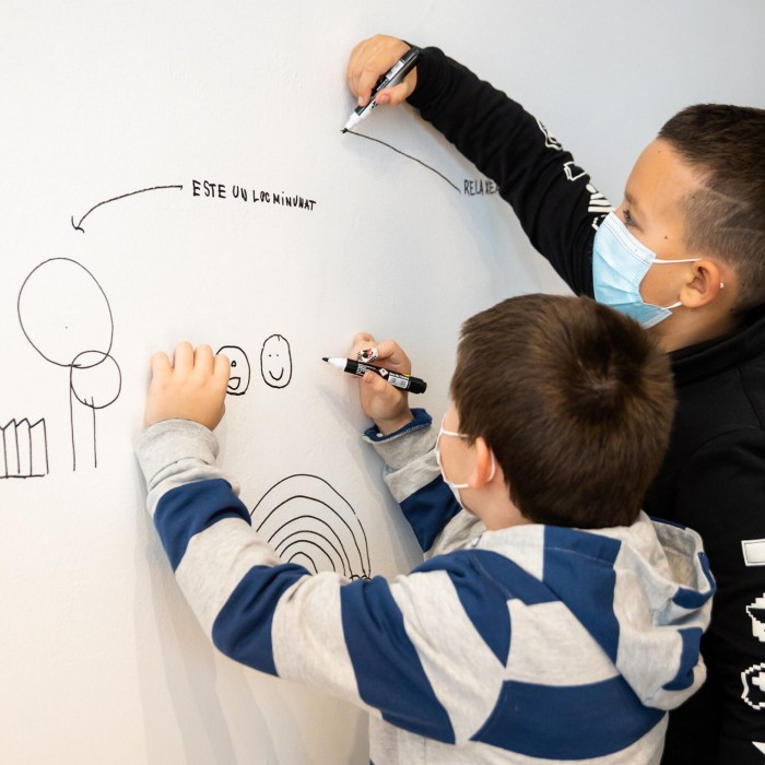 two children writing on a whiteboard