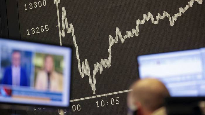 A trader watches news on a television monitor at the Frankfurt Stock Exchange