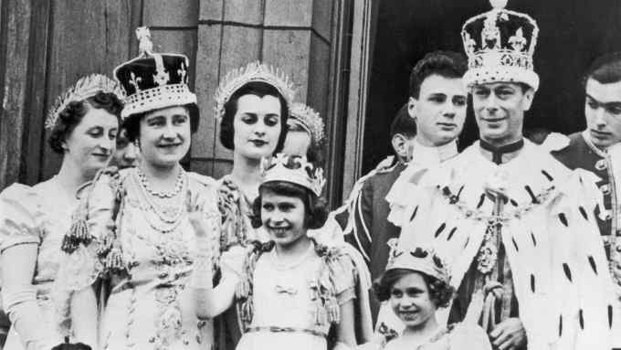 Princess Elizabeth, waving, with the royal family dressed in ermine and crowns, on the balcony of Buckingham Palace following the coronation King George VI in 1937