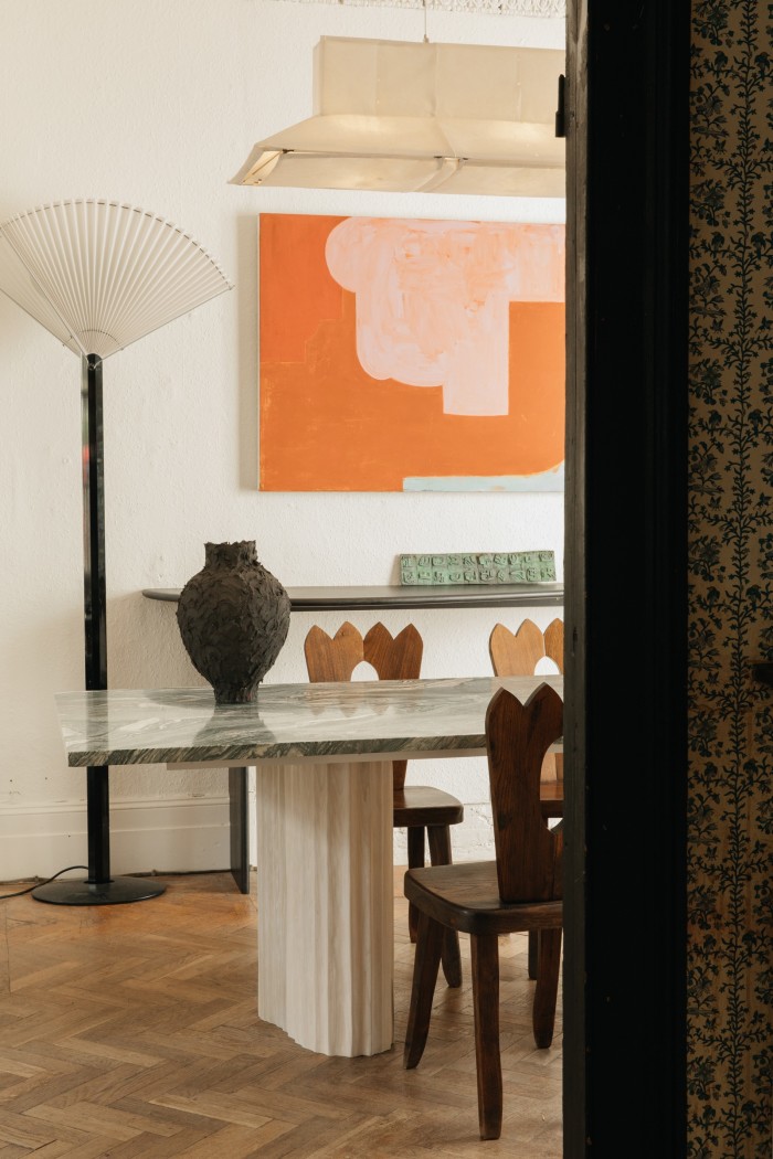 The dining room, with a table by EJR Barnes, ceramic vase by Noe Kuremoto, and Atelier LK Collection Tobia & Afra Scarpa lamp, Olavi Hanninen dining chair and artwork by Joseph Goody