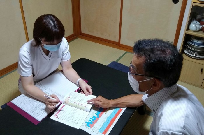 Next steps: a healthcare worker at Showa Inan General Hospital discusses a long-term care plan with a stroke patient