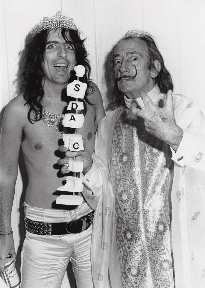 In 1973 with Salvador Dalí, who created a sculpture of Cooper’s brain made out of éclairs and ants. Below right