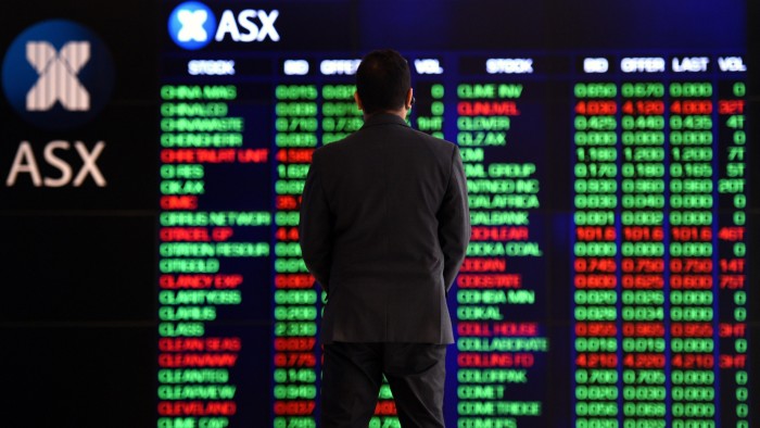 A person watches market gains displayed on the Australian Stock Exchange