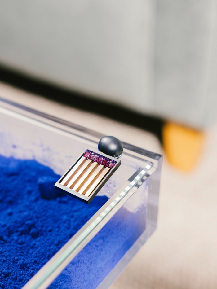 Hemmerle white-gold, rubellite, iron and bronze Earring (one of a pair) resting on a limited-edition Yves Klein Blue “IKB” Glass Table