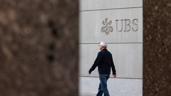A pedestrian passes the UBS headquarters in Zurich