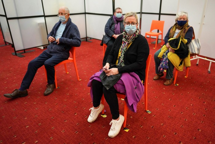 People wait in a post-vaccine observation area after receiving the Oxford/AstraZeneca vaccine at a centre in Newcastle upon Tyne, England