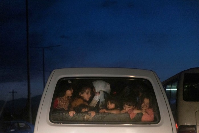 Children ride in the back of a vehicle near the Hamid Karzai International Airport in Kabul August 28
