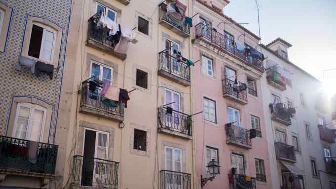 Clothes are hung out to dry on the balconies of residential apartments in Lisbon