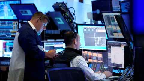 A pair of traders work on the floor of the New York Stock Exchange