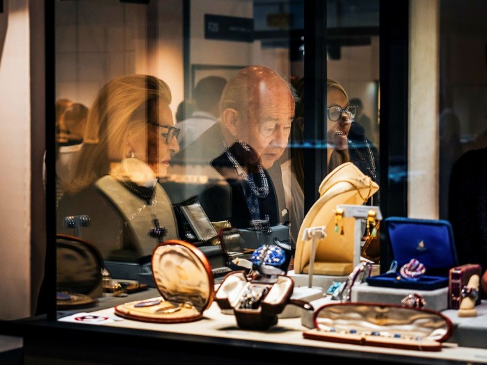 Persons looking at vintage jewellery in a glass display