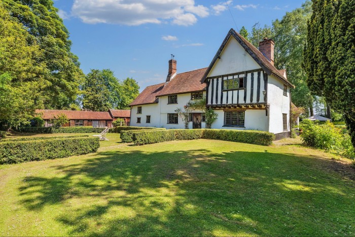 A large detached house with Tudor features on a neat lawn
