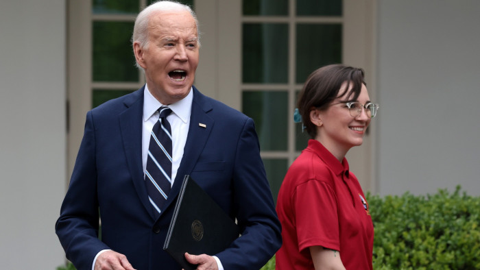 Joe Biden smiles while talking in the White House Rose Garden.