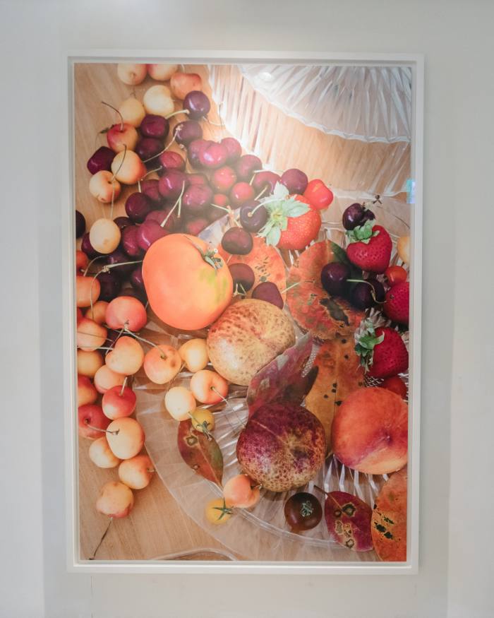 A detailed photograph shows an array of fruit on glassware on a wooden surface 
