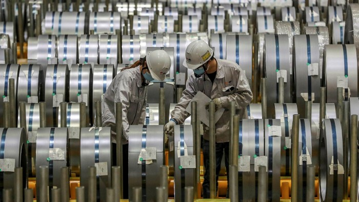 Workers check rolls of sheet aluminium at a factory in Wuhan, China