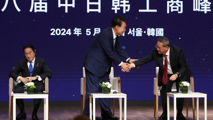 South Korea’s President Yoon Suk Yeol shakes hands with China’s Premier Li Qiang, as Japan’s Prime Minister Fumio Kishida looks on