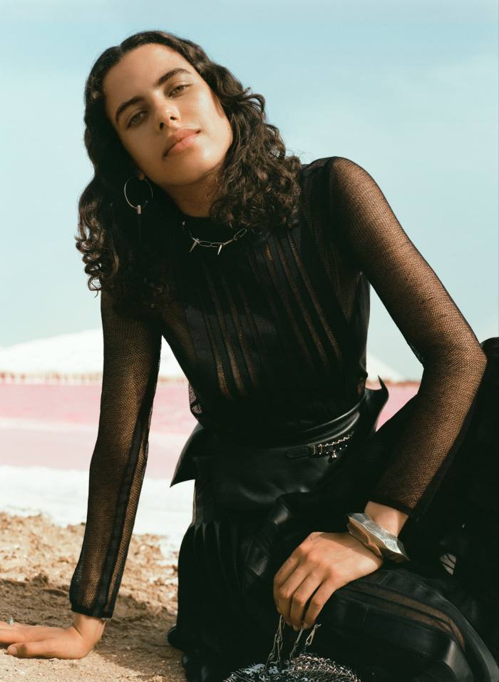 Hermès sheer wool jumper, £2,400, and leather and mesh pleated skirt, £12,200. Mawé Attaher silver and ebony earrings, €245. Justine Clenquet  brass-dipped palladium necklace, €150. Saint Laurent by Anthony Vaccarello metal and glass ring, £275, and metal bangle, £995. Paco Rabanne brass 1969 nano bag, €740