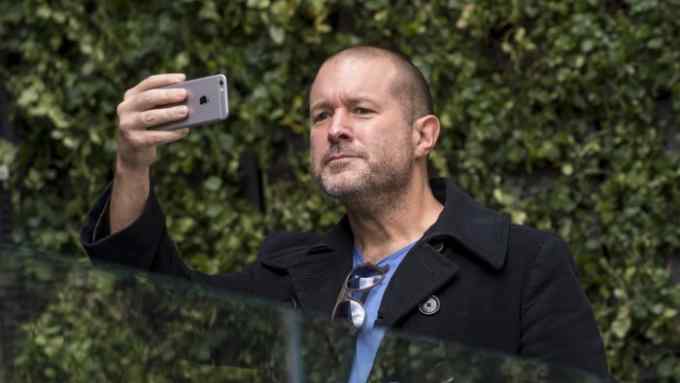 Jonathan &quot;Jony&quot; Ive, chief design officer for Apple Inc., uses an Apple iPhone to take a photograph of the &quot;plaza&quot; area during the grand opening of the company's new flagship store at Union Square in San Francisco, California, U.S., on Saturday, May 21, 2016. The flagship location boasts 40-foot-tall doors opening onto the square and comprises five departments, or what Apple prefers to call &quot;features.&quot; Photographer: David Paul Morris/Bloomberg