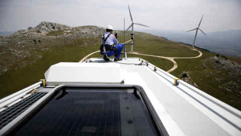 An employee works on an anemometer, used to measure the wind speed located on the top of a wind turbine unit manufactured by Gamesa Corp. Tecnologica SA and operated by Enel Green Power SpA, the clean-energy unit of Italy's biggest utility Enel SpA at their wind farm in Frosolone, Italy, on Tuesday, July 29, 2014. Enel SpA, Italy's largest utility, will steer investments into Latin America and renewable energy as recession damps electricity demand in its biggest market. Photographer: Alessia Pierdomenico/Bloomberg