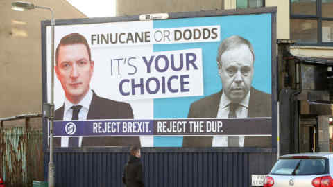 TO GO WITH GENERAL ELECTION PIECE FROM NORTHERN IRELAND BY ARTHUR BEESLEY: A man walks past a new Sinn Fein General Election Poster showing their candidate John Finucane verses DUP candidate Nigel Dodds on a billboard in north Belfast, Monday, Nov 11, 2019. Photo/Paul McErlane