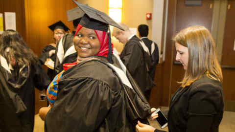 IMAGE DISTRIBUTED FOR HULT INTERNATIONAL BUSINESS SCHOOL - Mariama Bassama, left, is helped with her hood by Charlotte Pandraud before the Commencement Ceremony for Hult International Business School, Wednesday, Aug. 24, 2016 in Boston. Hult conferred diplomas to MBA, Masters of Finance, Masters of International Business and Masters International Marketing students from over 75 nationalities. (Scott Eisen/AP Images for Hult International Business School)