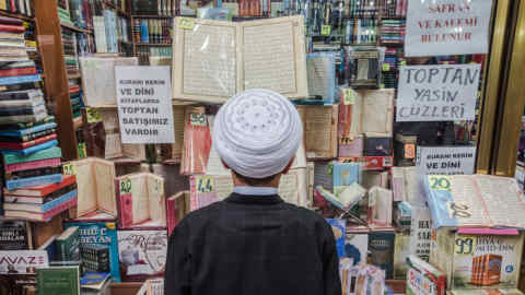An adolescent boy views Islamic texts through the window of a religious bookstore in the ultra-conservative Fatih neighborhood of Istanbul, Turkey, on 6 May 2018.
