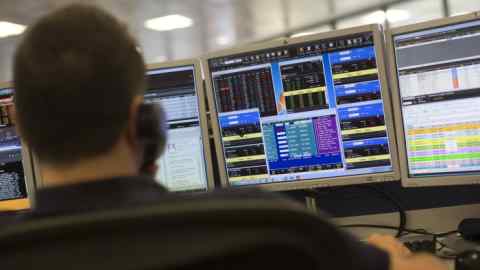 Trading At IG As They Announce Their Annual Results...A dealer looks at financial data on computer screens on the trading floor of IG Group Holdings Plc in London, U.K., on Tuesday, July, 21, 2015. IG Group Holdings Plc fell the most in more than six months after the spread-betting firm reported a 13 percent drop in full-year profit, hurt by the Swiss National Bank's surprise decision in January to scrap a currency cap. Photographer: Simon Dawson/Bloomberg