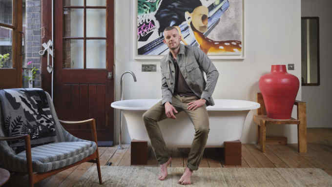 SPECIAL PRICE. Actor Russell Tovey with his art collection. He as been an Art collector for a number of years now starting out with some Tracey Emin prints. Artwork above the bath is by Jamie Juliano Villani credit Amit Lennon /Camerapress
