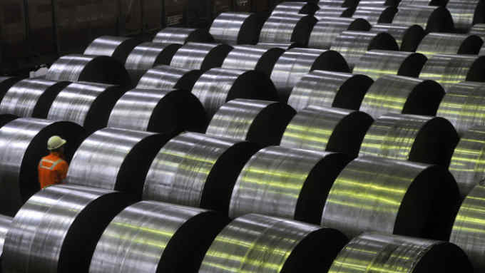 An employee passes coils of flat rolled steel produced by the Zelezara Smederevo doo steel plant in Smederevo, Serbia, on Wednesday, Jan. 21, 2015. Esmark Europe BV submitted the only valid bid out of two in a tender for 80 percent of Zelezara Smederevo doo, Finance Minister Dusan Vujovic told reporters in Belgrade. Photographer: Oliver Bunic/Bloomberg