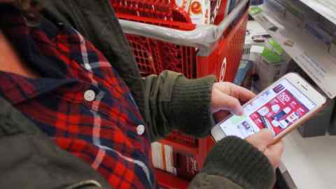 OREM, UT - NOVEMBER 24: A shopper checks out &quot;Black Friday&quot; deals on her smartphone at a Target on November 24, 2016 in Orem, Utah. Retailers kicked off the unofficial start of the holiday season with sales that in many instances began on the Thanksgiving holiday. (Photo by George Frey/Getty Images)