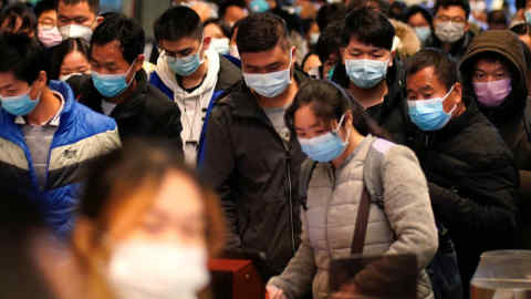 FILE PHOTO: Passengers wearing face masks arrive at a railway station in Wuhan on the first day inbound train services resumed following the novel coronavirus disease (COVID-19) outbreak, in Wuhan of Hubei province, the epicentre of China's coronavirus outbreak, March 28, 2020. REUTERS/Aly Song/File Photo