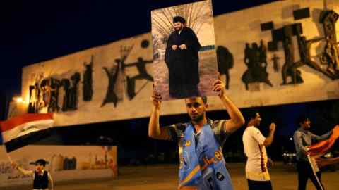 An Iraqi supporter of Sairun list celebrates with portraits of Shi'ite cleric Moqtada al-Sadr, after results of Iraq's parliamentary election were announced in Baghdad, Iraq May 14, 2018. REUTERS/Thaier al-Sudani
