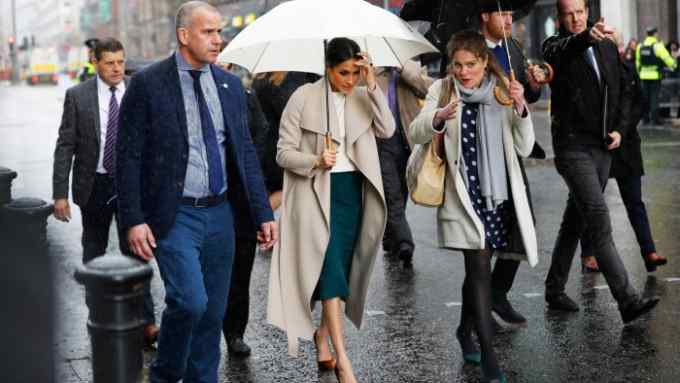 The fiancee of Britain's Prince Harry, Meghan Markle, shelters under an umbrella after visiting the Crown Bar in Belfast, Northern Ireland March 23, 2018.  REUTERS/Darren Staples - RC12653DCB00