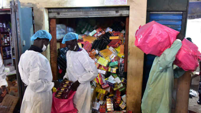Health Ministry employees empty shops selling fake medicine during a raid against shops selling counterfeit drugs on May 3, 2017 at the Adjame market in Abidjan. / AFP PHOTO / ISSOUF SANOGO (Photo credit should read ISSOUF SANOGO/AFP/Getty Images)