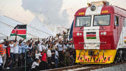 People cheer and throw confetti, after Kenyan President Uhuru Kenyatta flags off a cargo train for its inaugural journey to Nairobi, at the port of the coastal town of Mombasa on May 30, 2017. More than a century after a colonial railway gave birth to modern Kenya, the country is betting on a new Chinese-built route to cement its position as the gateway to East Africa. The $3.2 billion (2.8 billion euro) railway linking Nairobi with the port city of Mombasa will May 31 take its first passengers on the 472 kilometre (293 mile) journey, allowing them to skip a hair-raising drive on one of Kenya's most dangerous highways. / AFP PHOTO / TONY KARUMBA (Photo credit should read TONY KARUMBA/AFP/Getty Images)