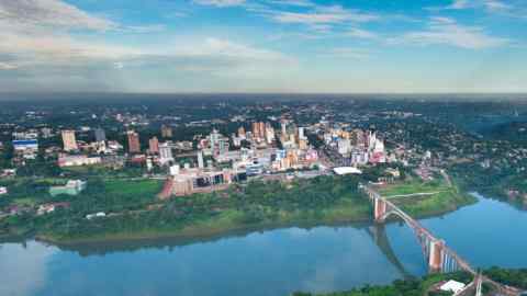 M96C23 Aerial view of the Paraguayan city of Ciudad del Este and Friendship Bridge, connecting Paraguay and Brazil through the border over the Parana River,