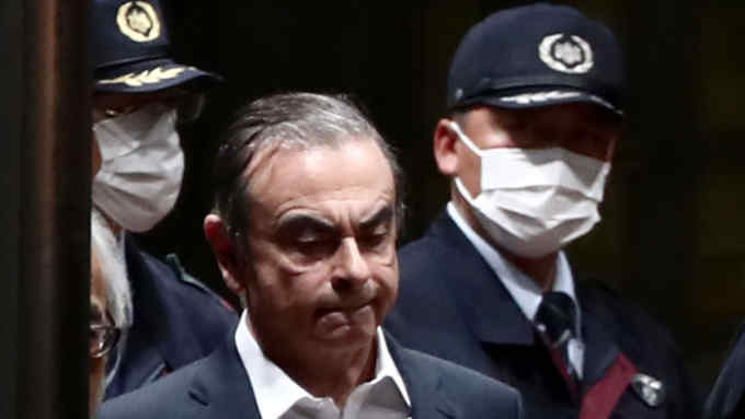 Former Nissan chairman Carlos Ghosn (C) is escorted as he walks out of the Tokyo Detention House following his release on bail in Tokyo on April 25, 2019. - Ghosn left his Tokyo detention centre after winning bail on April 25 to prepare his defence against multiple charges of financial misconduct. (Photo by Behrouz MEHRI / AFP) / ALTERNATIVE CROPBEHROUZ MEHRI/AFP/Getty Images