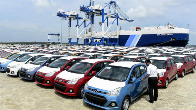 TO GO WITH SriLanka-economy-infrastructure,FOCUS by Amal Jayasinghe In this photograph taken on February 10, 2015, a Sri Lankan official looks at cars standing at the port facility at Hambantota. From a multi-million dollar airport ignored by airlines to a lavish cricket stadium rejected by players, Sri Lanka's new government is mulling the future of a string of white elephants. AFP PHOTO / LAKRUWAN WANNIARACHCHI (Photo credit should read LAKRUWAN WANNIARACHCHI/AFP/Getty Images)