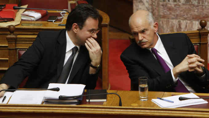 Finance Minister George Papakonstantinou, left, talks with Greek Prime Minister George Papandreou during a debate in Parliament on the country's planned new austerity measures on Thursday, May 6, 2010. Papandreou said Greece's only hope of avoiding bankruptcy is to approve the measures to secure money from a joint EU and International Monetary Fund rescue package. He spoke during a heated debate overshadowed by the deaths of three people during protests against spending cuts. The 300-member house, in which the governing Socialists hold a strong majority, was due to approve the law later Thursday. (AP Photo/Petros Giannakouris)