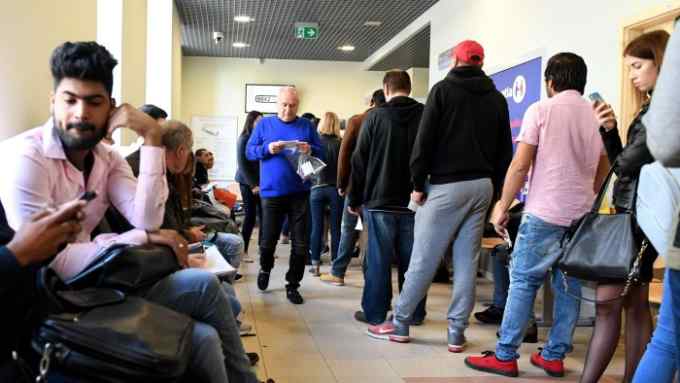 People wait at the regional department of foreigners' affairs where foreigners can get work and residency permits in central Warsaw on April 26, 2018. - To keep its economy growing, Poland is banking on workers from abroad. (Photo by JANEK SKARZYNSKI / AFP) / TO GO WITH AFP STORY by Michel VIATTEAU (Photo credit should read JANEK SKARZYNSKI/AFP via Getty Images)
